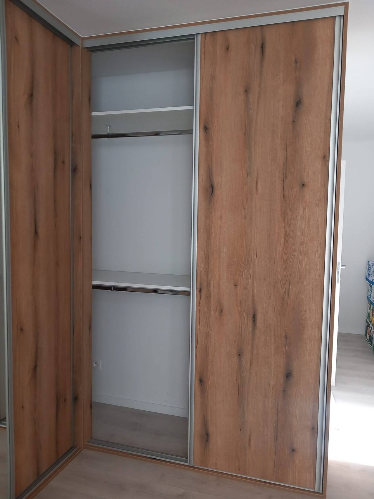 Offener Eichenkasten mit zwei Kleiderstangen im Dachgeschoss