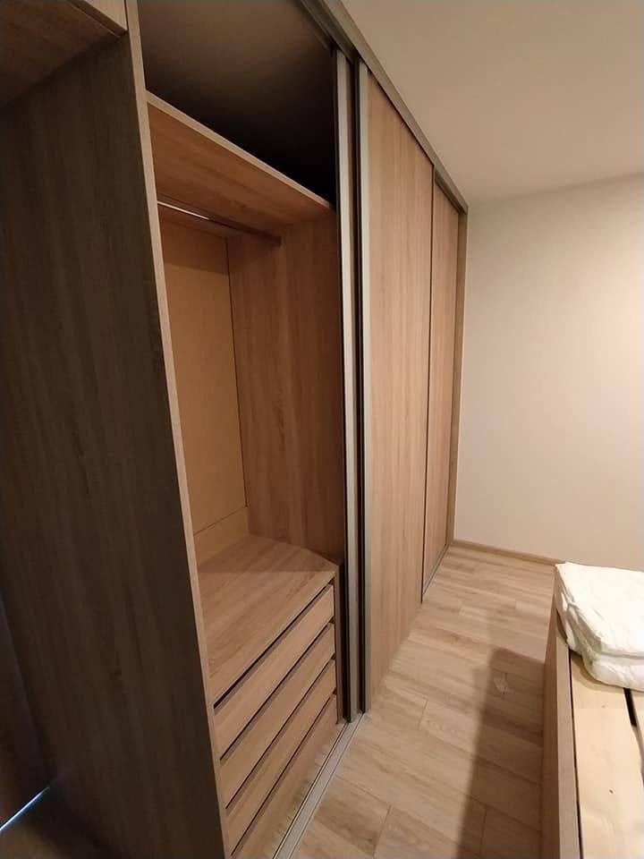 Geöffnete Tür gibt Kleiderstange und Laden in Eiche-Dekor frei