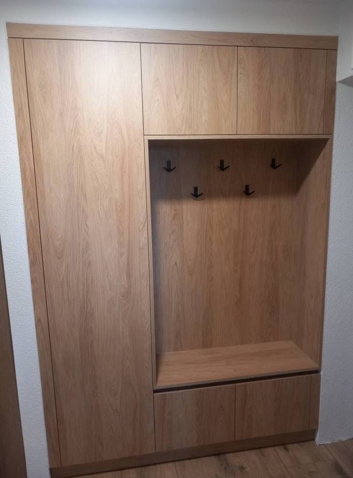 Schrägansicht der Eichenwand mit Oberkästen und Sitzbank