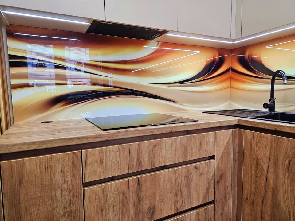 Kochfeld und Abwasch vor der Glasrückwand mit Wellenmotiv