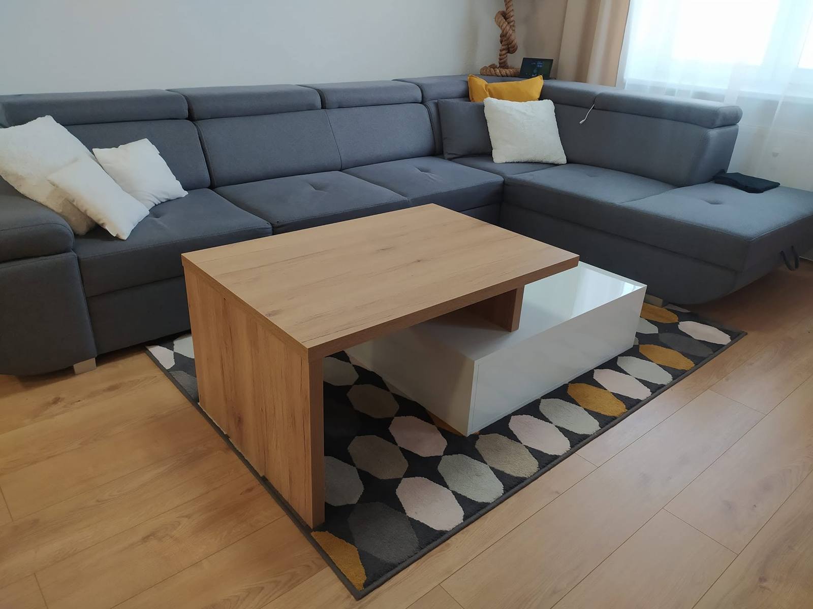 Couchtisch in Eichenoptik vor dem grauen Ecksofa