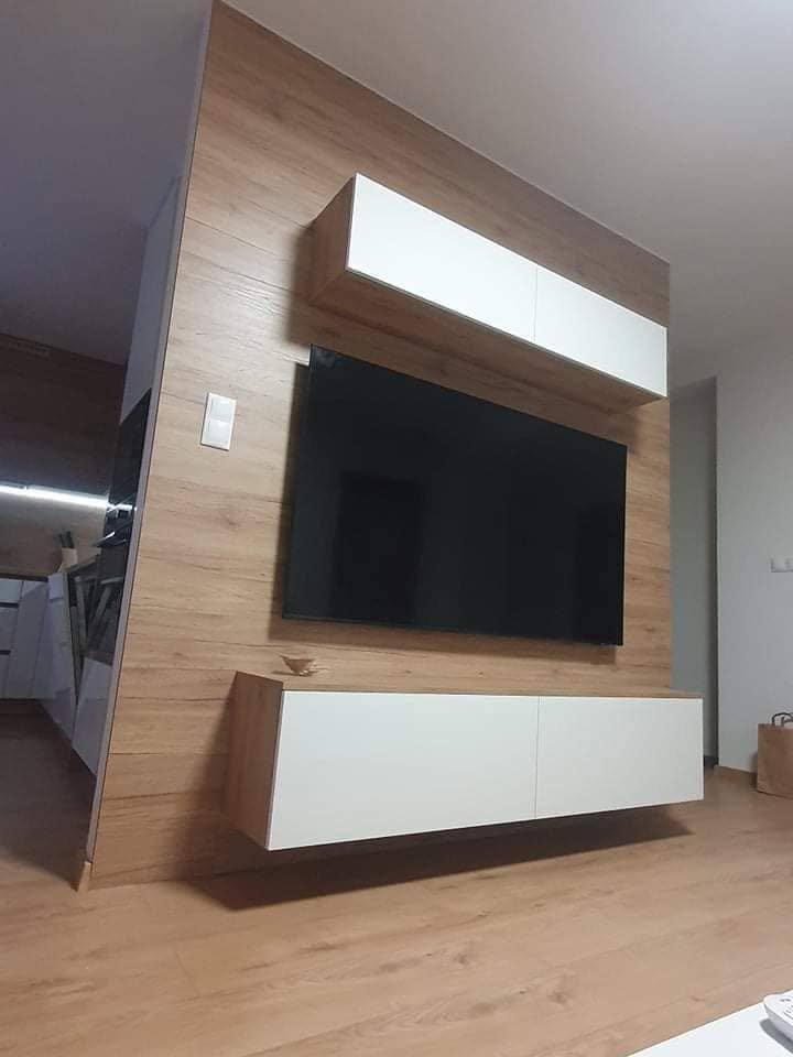 Schräge Ansicht der weißen Kästen über und unter dem Fernseher