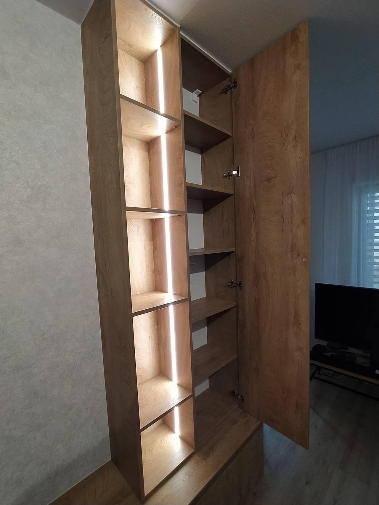 Geöffnete Tür des hohen Kastens mit Fachböden neben den Lichtfächern
