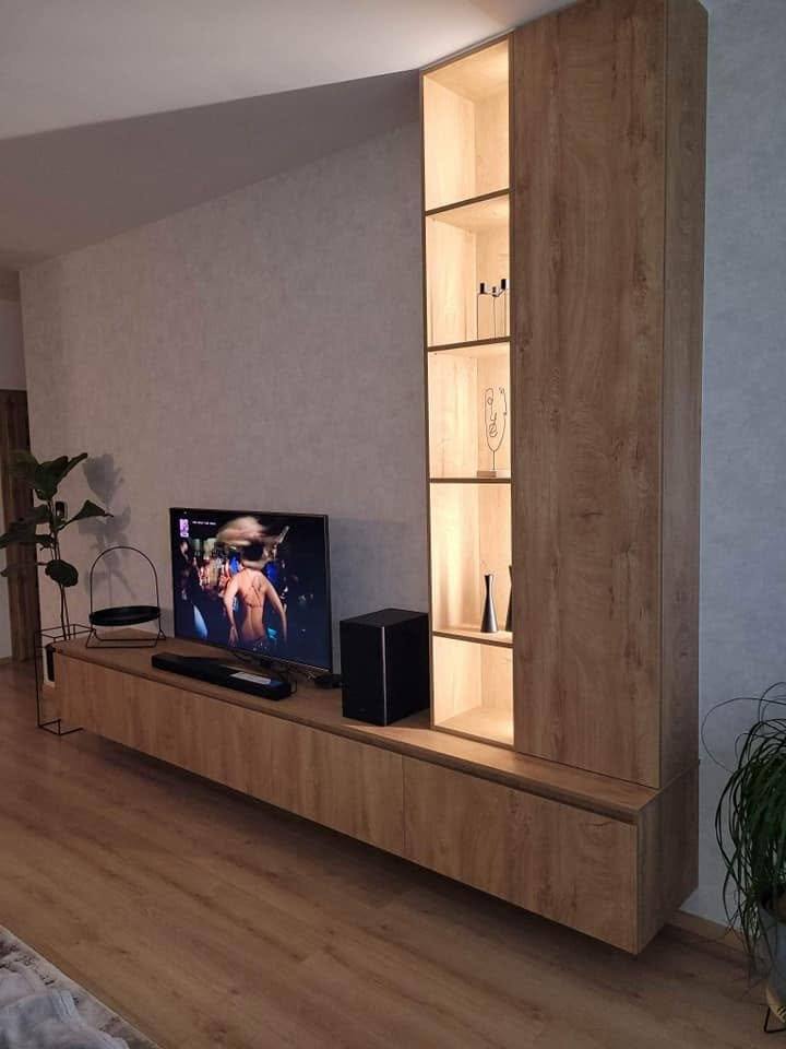 Niedriges Lowboard mit Fernseher und beleuchteten Fächern daneben