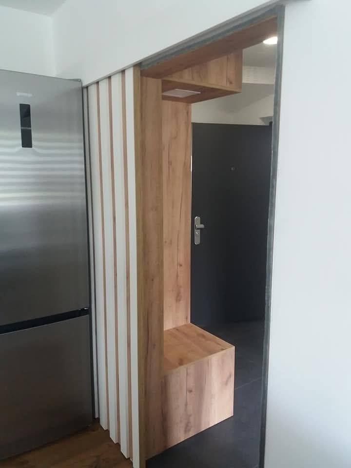 Eichennische mit Sitzbank und Leuchte, links ein Edelstahlkühlschrank