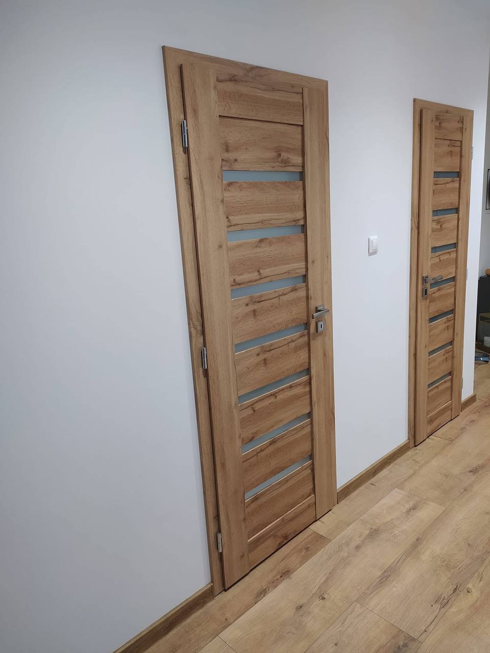 Zwei Eichentüren mit Glasstreifen im hellen Flur