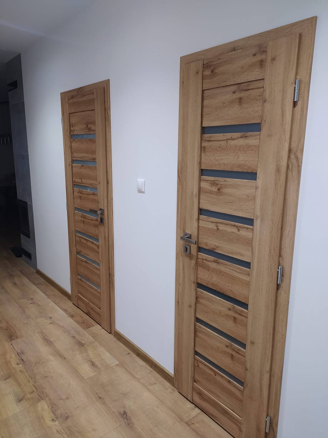 Chodba s dubovými dverami s vodorovnými sklenenými pásmi