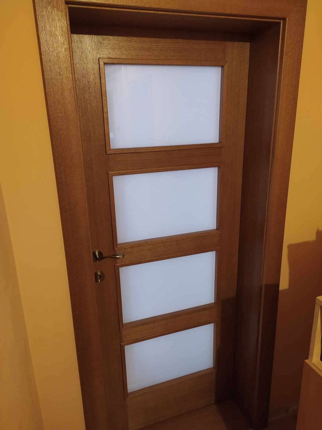 Dubové dvere so štyrmi sklenenými výplňami pri schodisku a farebnej stene