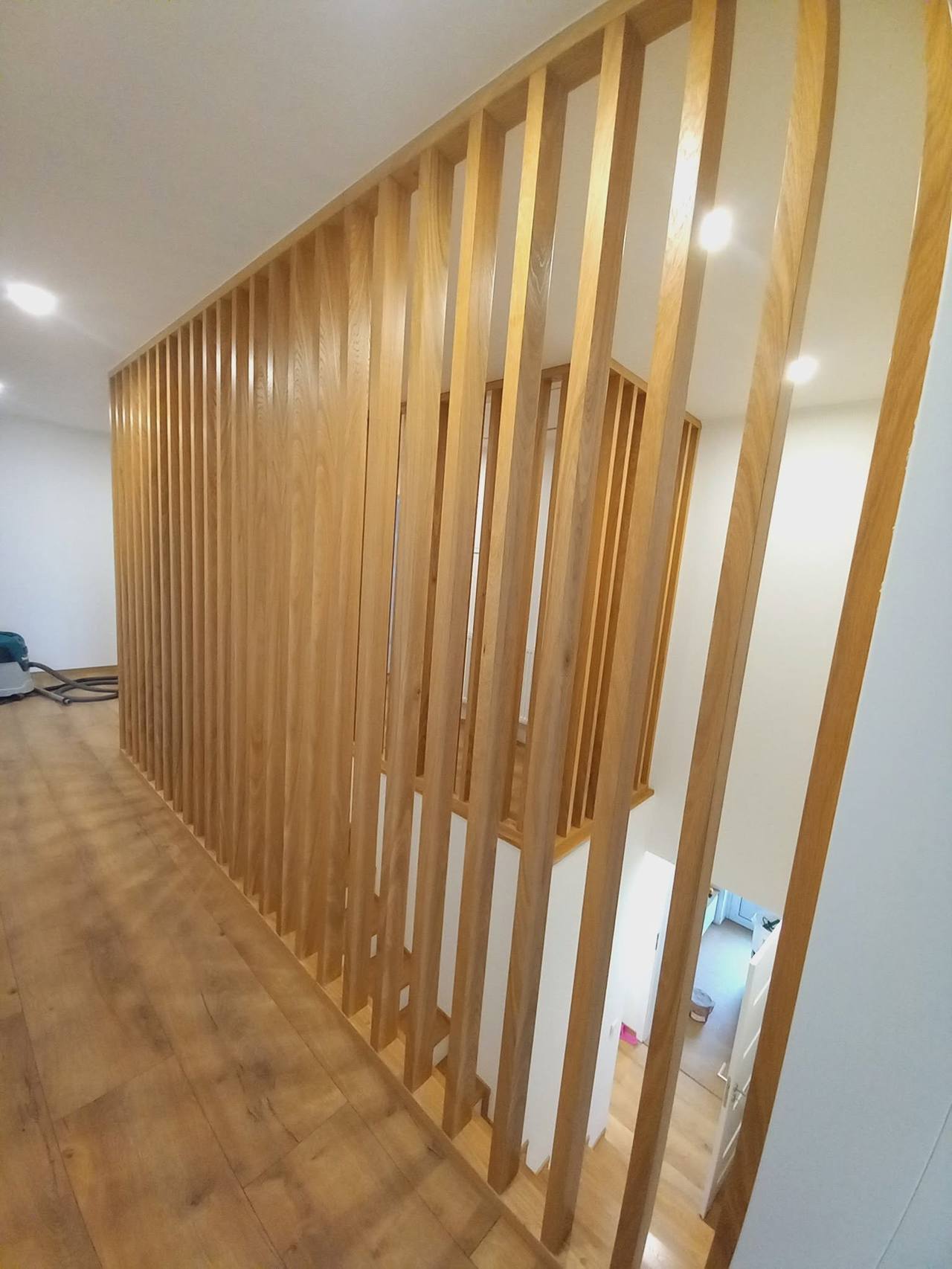Langer Blick entlang der Eichenlamellenwand im Gang