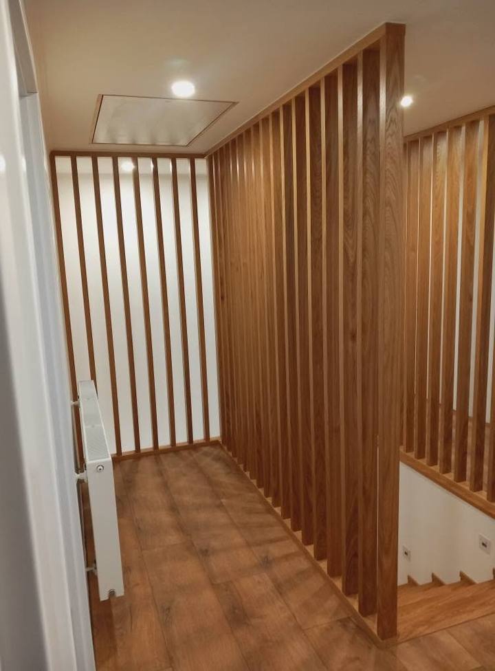 Lamellenwand aus Eiche rund um die Stiege im Obergeschoß