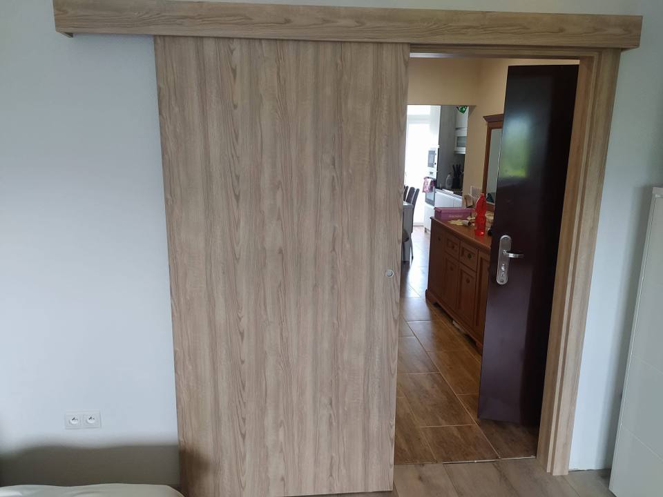 Eichenfarbene Schiebetür an der Wand mit Blick ins Nebenzimmer
