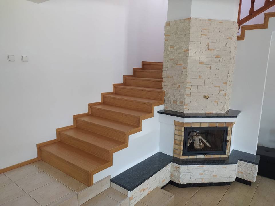 Eichenstiege beim Kamin mit der Natursteinwand
