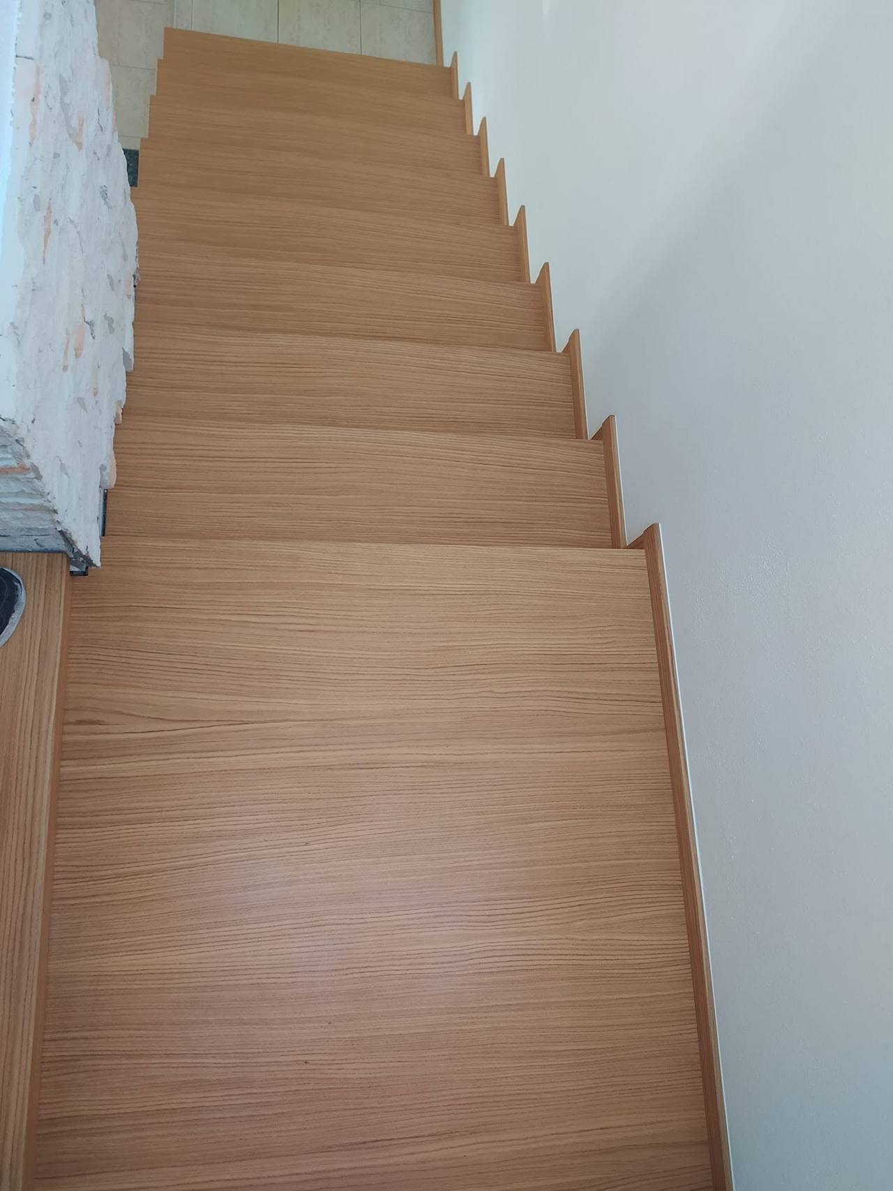 Rovné dubové schody pri pohľade zhora s kamenným obkladom