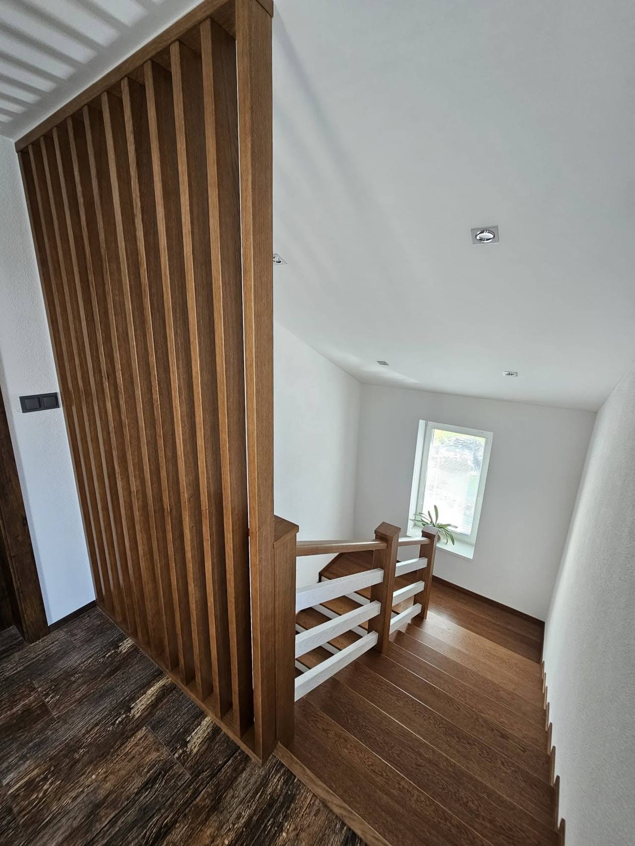 Eichenlamellenwand entlang der Stiege Richtung Gang