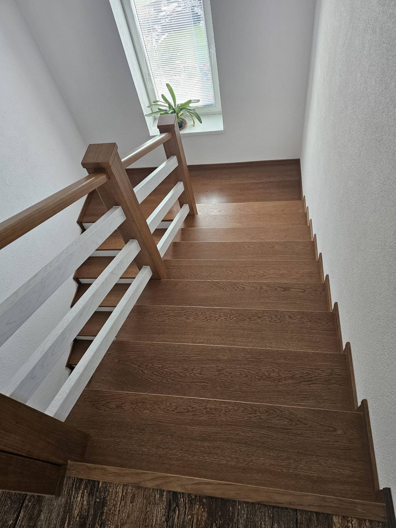 Dunkle Eichenstiege mit Geländer mit weißen Sprossen