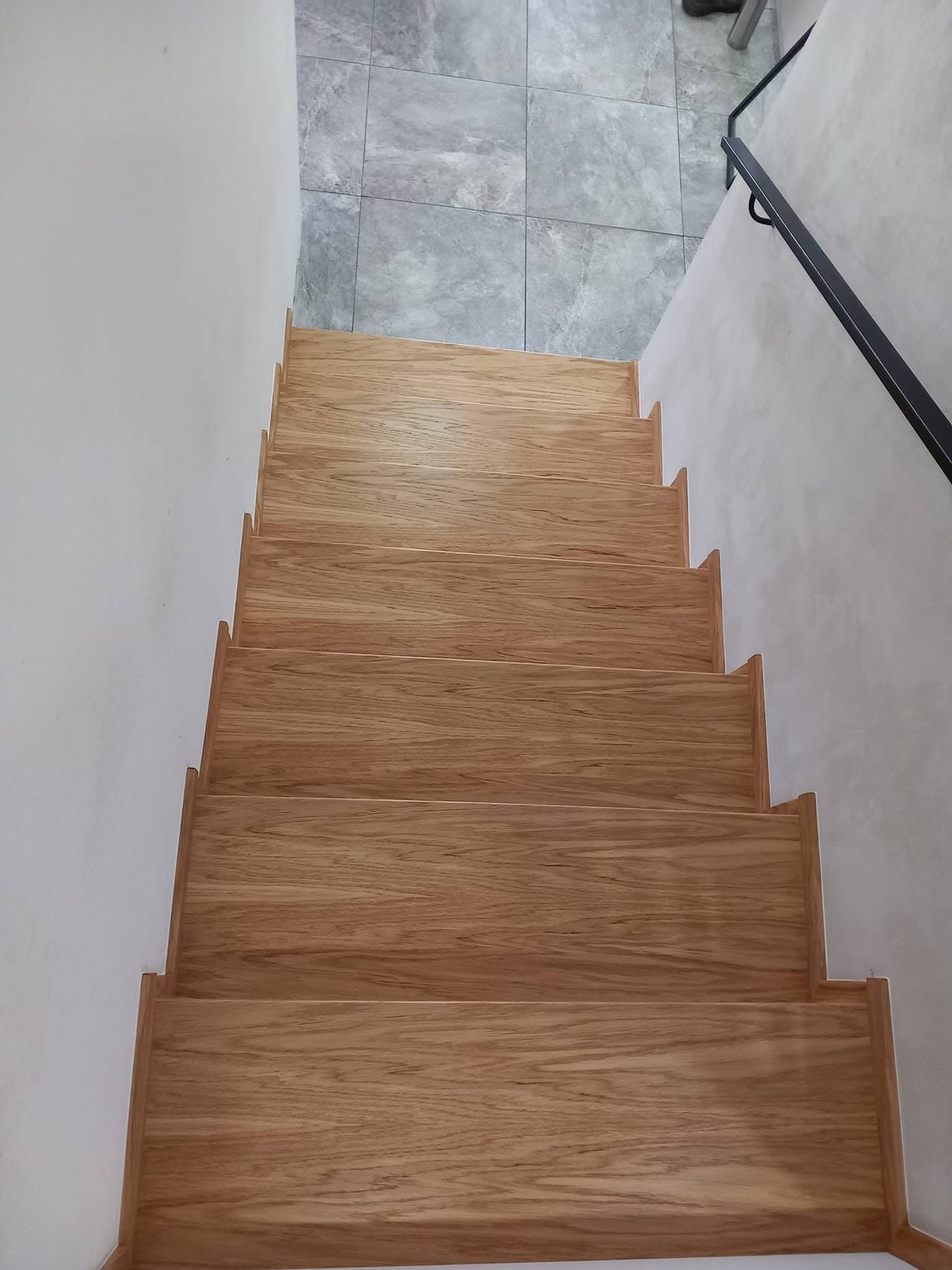 Eichenstiege mit schwarzem Metallhandlauf von oben gesehen