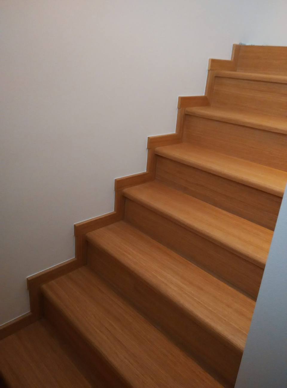 Eichenstiege mit hellen, kontrastarmen Setzstufen von unten gesehen