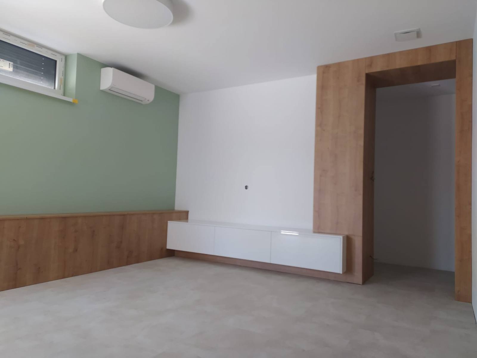 Schlafzimmer mit Türportal in Eichendekor und niedriger Box an der Wand