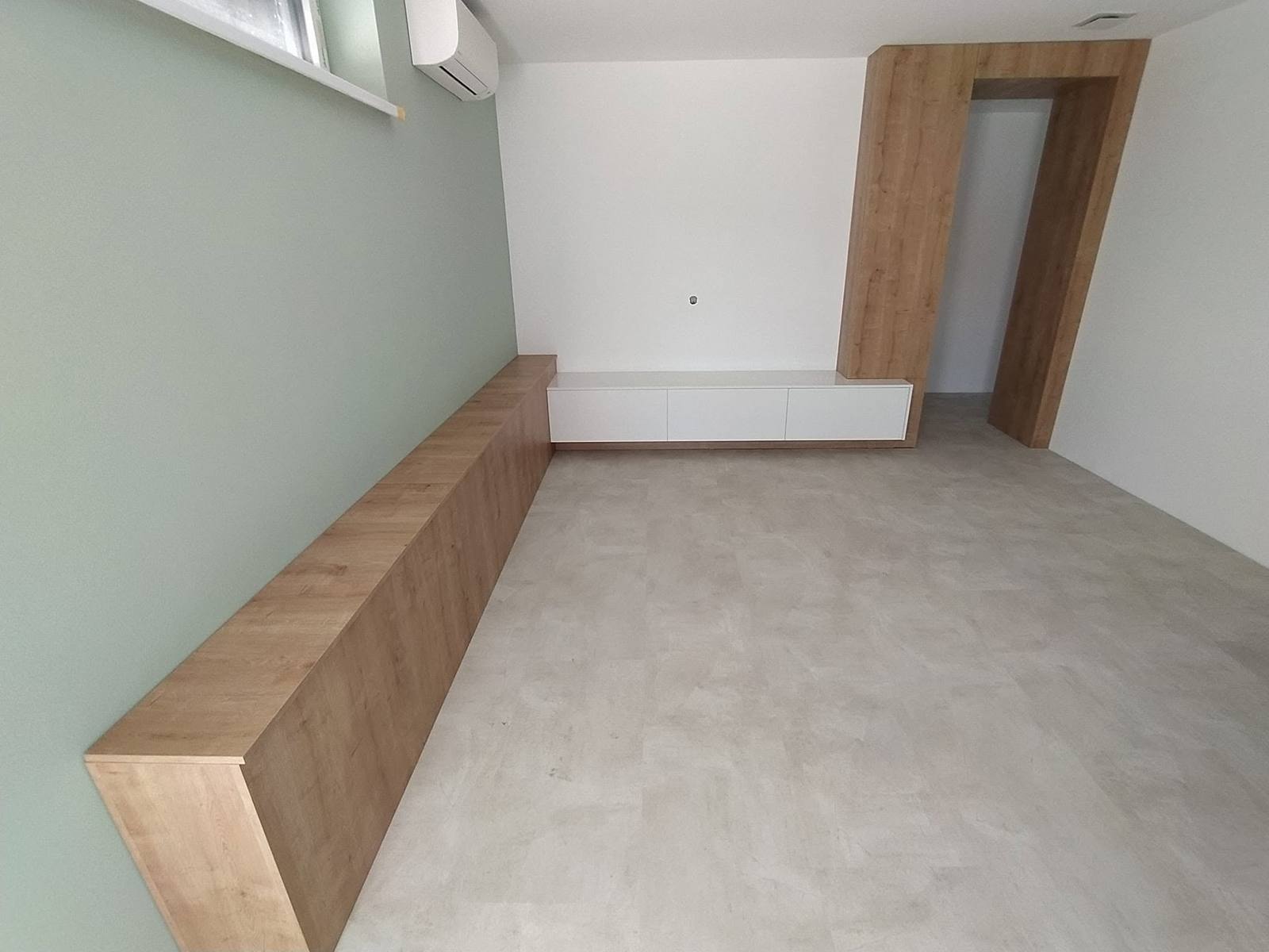 Niedrige Box in Eichendekor und Türportal im leeren Schlafzimmer