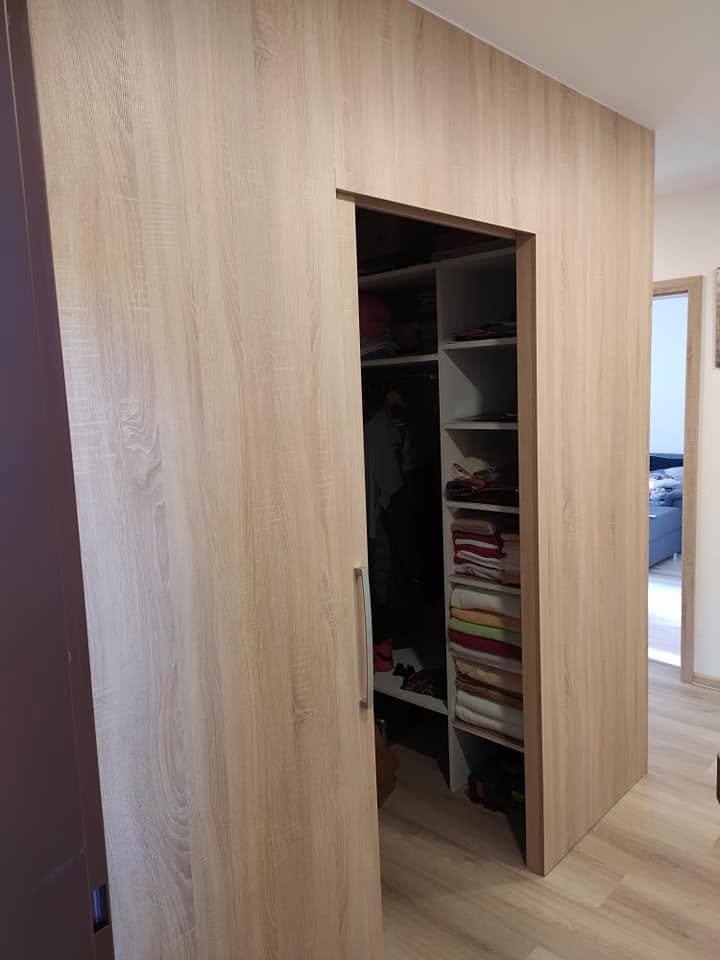 Dubový šatníkový box s pohľadom do vnútra na police a oblečenie.