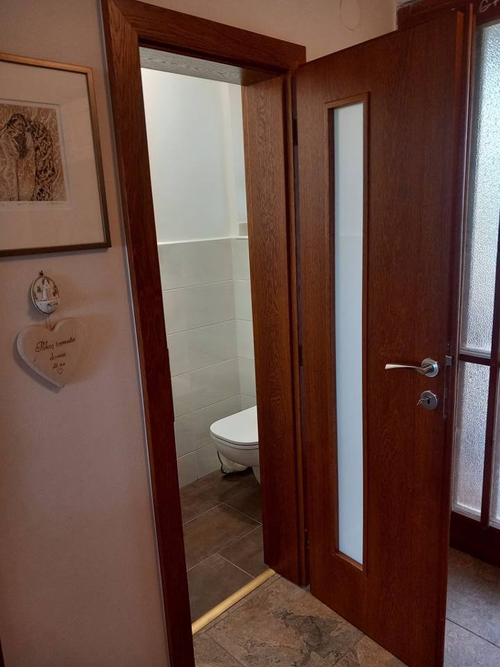 Offene Nussbaumtür mit Verglasung zur Toilette