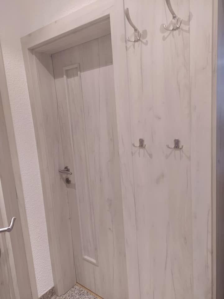 Helle Eichentür mit Fräsung neben der Garderobe
