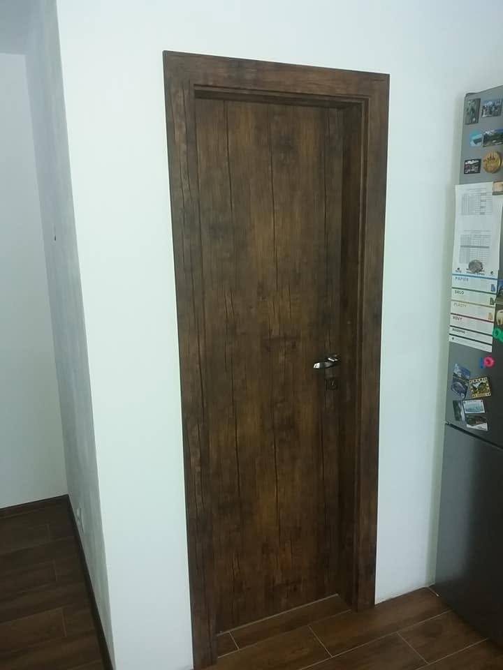Dunkle Eichentür mit Türstock beim Kühlschrank