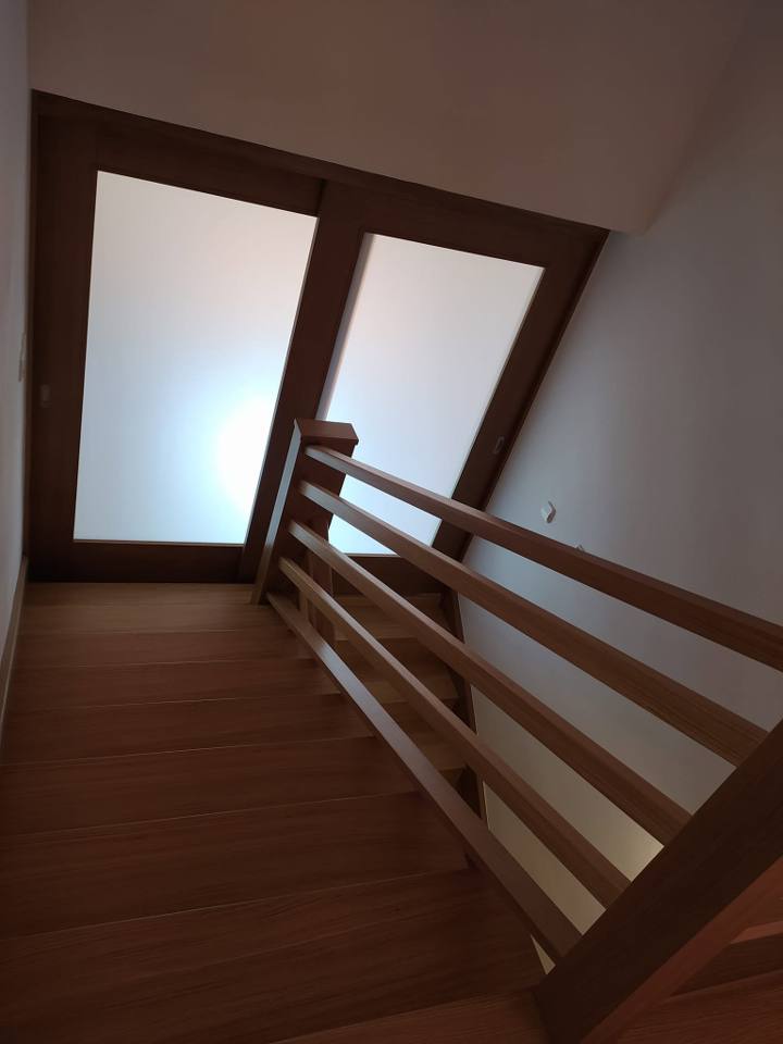 Zweiflügelige Glastür über der Stiege mit Holzgeländer