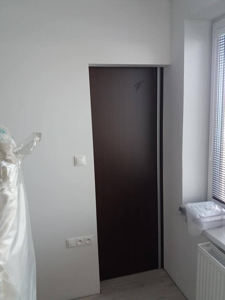 Dunkle Wenge-Zimmertür im weißen Raum beim Fenster