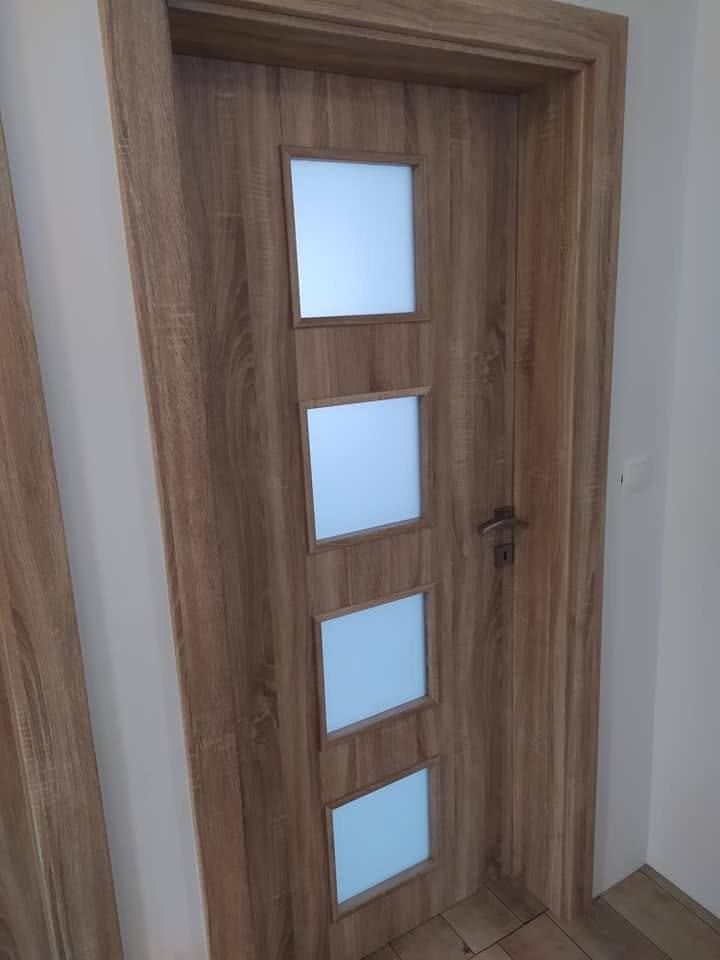 Tür in Eichendekor mit vier Glasfeldern beim Bereich mit Holzlamellen.