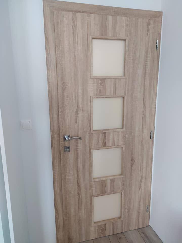 Helle Tür in Eichendekor mit vier quadratischen Milchglasfeldern.