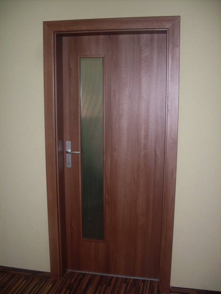 Tür in dunklem Holzdekor mit schmalem senkrechtem Glas