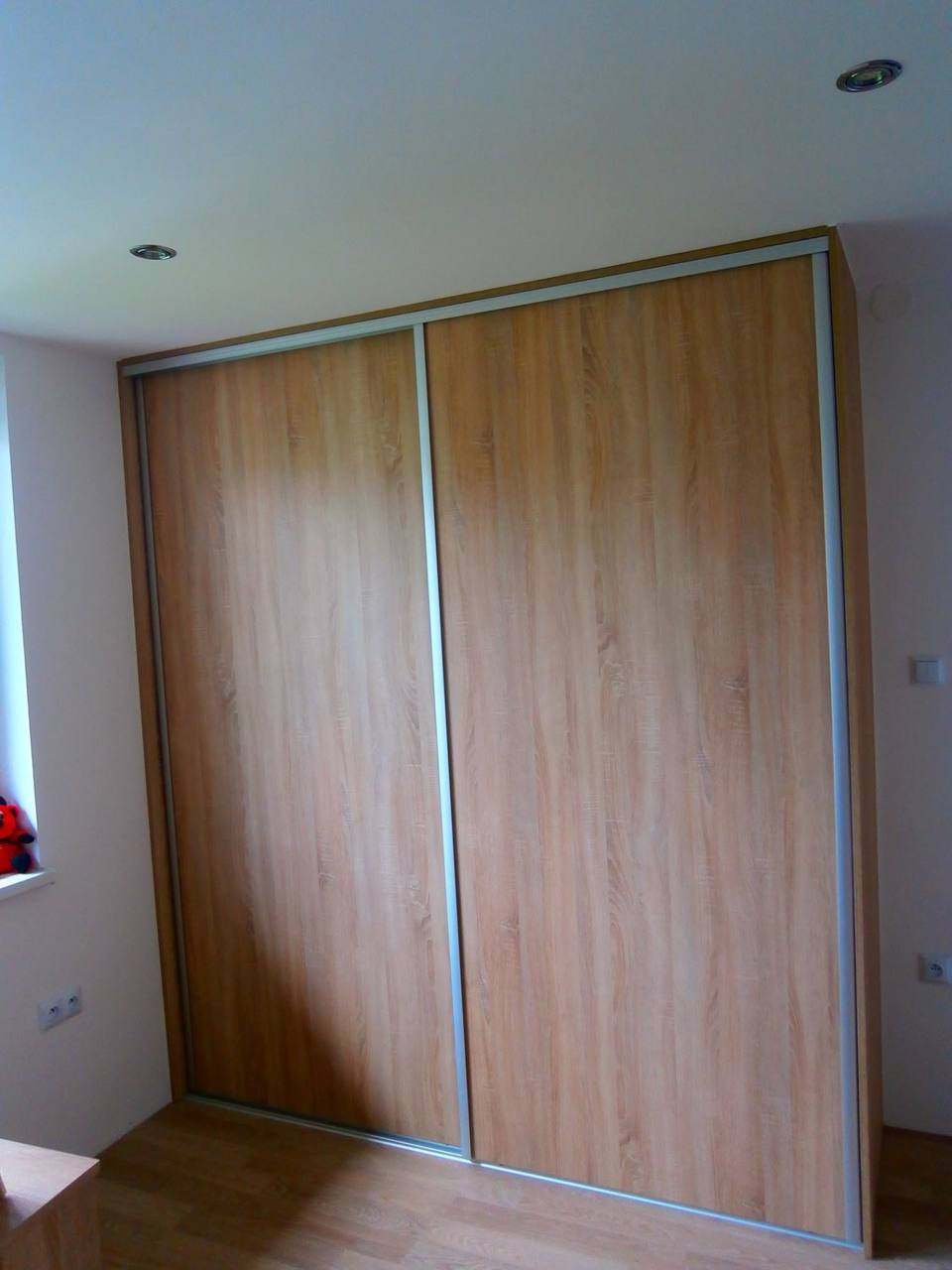 Zweiflügeliger Kleiderkasten in Kirschbaum-Dekor im Schlafzimmer.