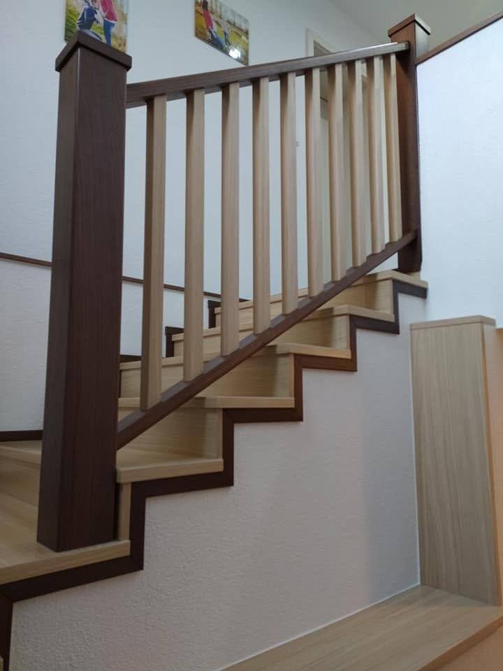 Stiege mit Geländer aus hellen Stäben und dunklem Handlauf