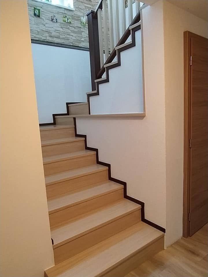 Helle Eichenstufen mit dunkler Einfassung entlang der Wand