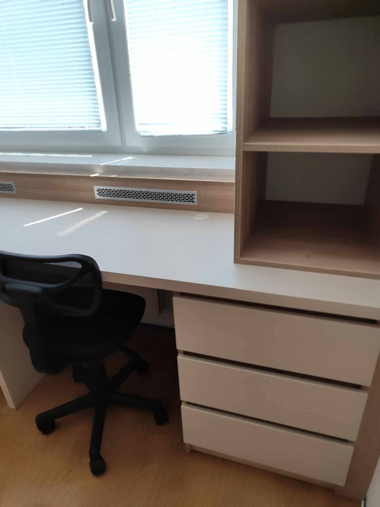 Detail des Schreibtischs mit cremefarbenen Laden und Eichenregal