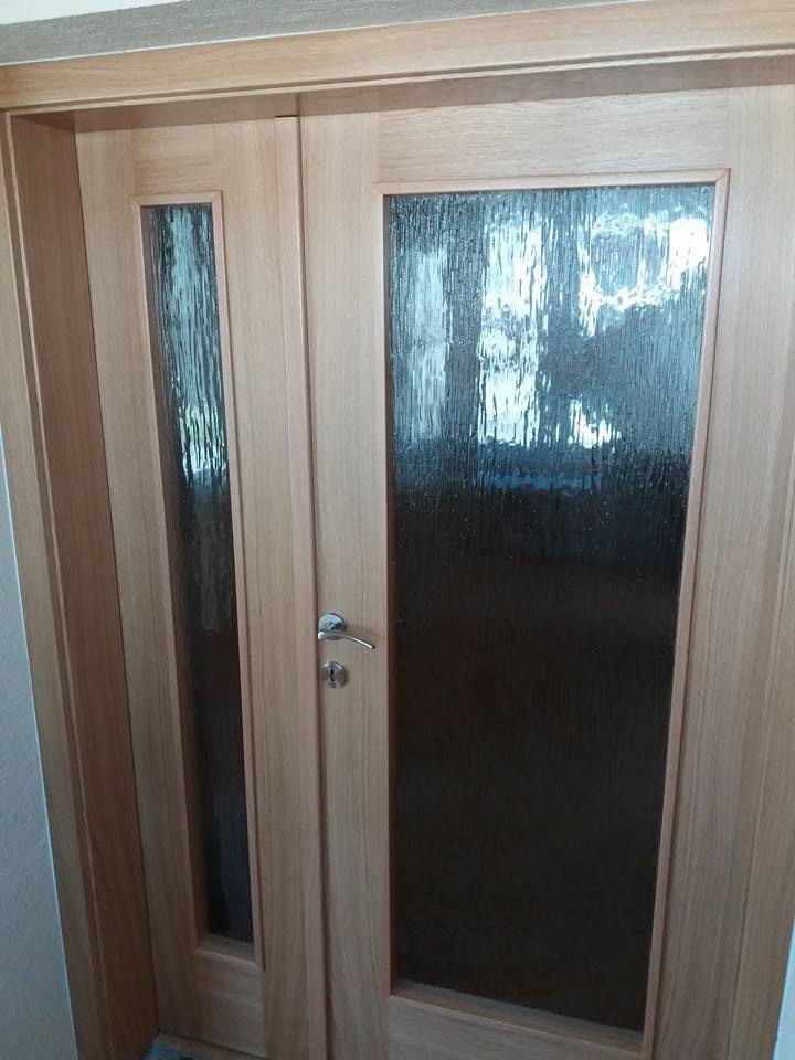 Zweiflügelige Tür in dunklerem Eichendekor mit großer strukturierter Glasfüllung.