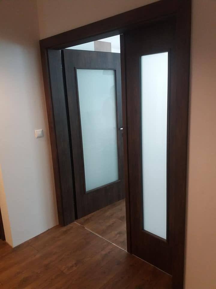 Geöffnete zweiflügelige dunkle Tür mit Glas zwischen Flur und Zimmer