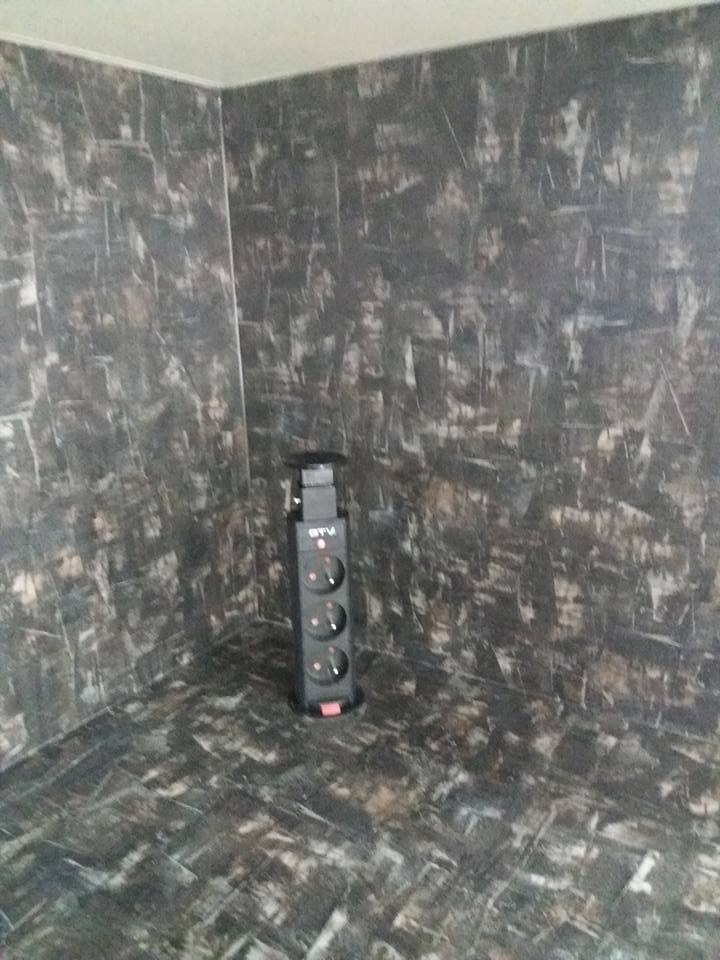 Versenkbare Steckdose in der Plattenecke vor Rückwand in Marmoroptik