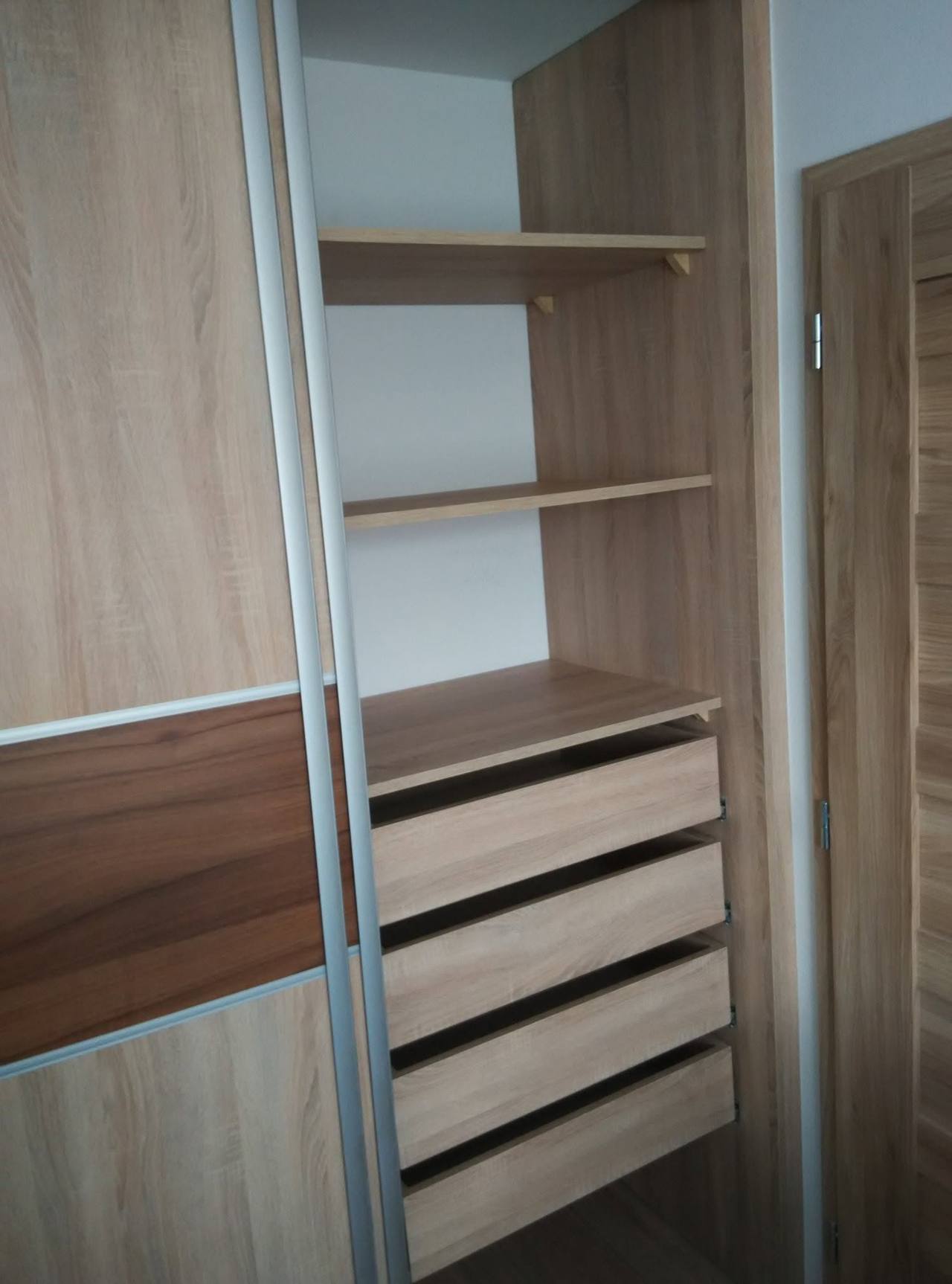 Innenraum des Eichen-Schiebetürkastens mit Laden und offenen Fachböden.
