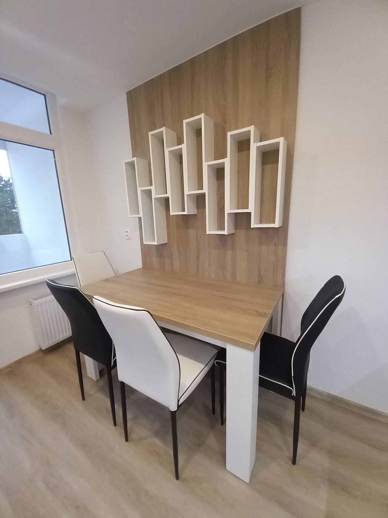 Essecke mit Eichentisch und Wand mit weißen Borden