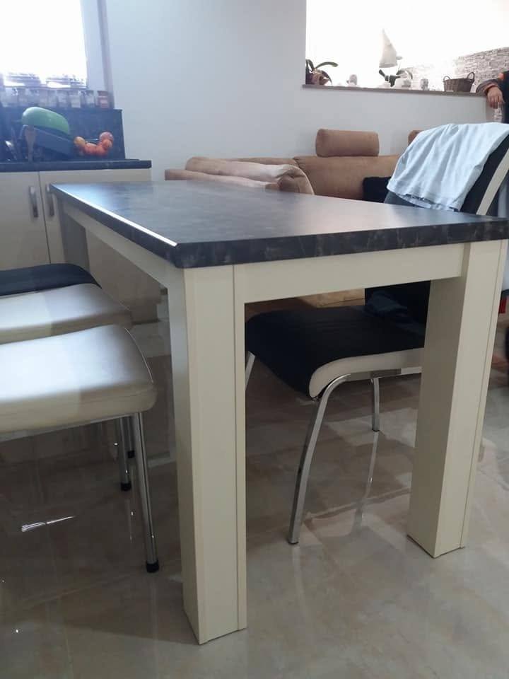 Esstisch mit dunkler Platte und Stühlen im Wohnzimmer