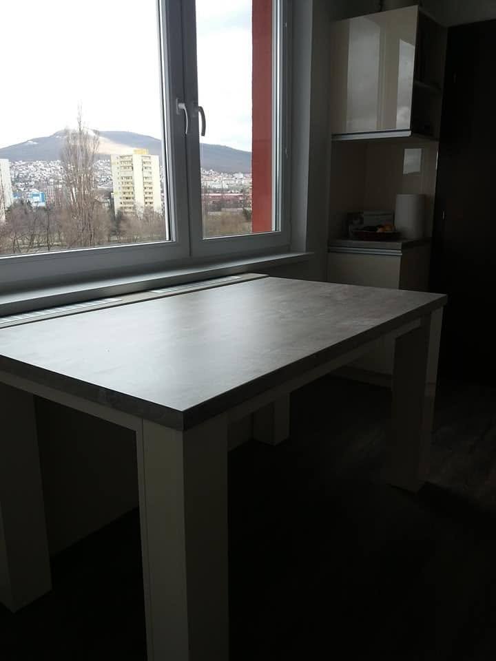 Tisch mit grauer Platte am Fenster mit Ausblick