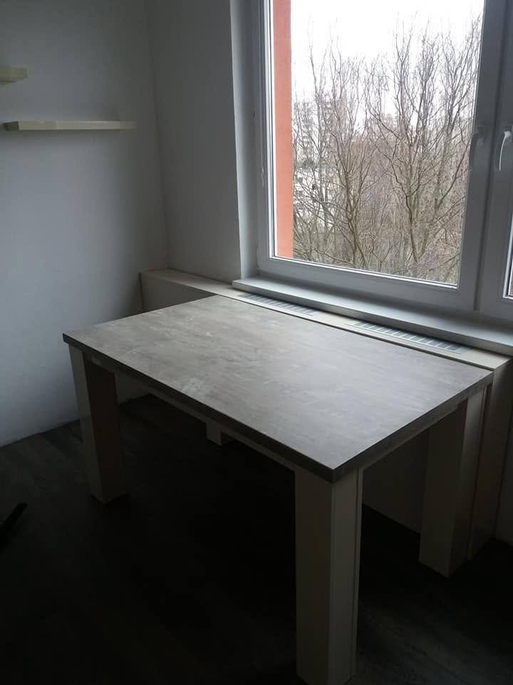 Esstisch mit grauer Platte am Fenster