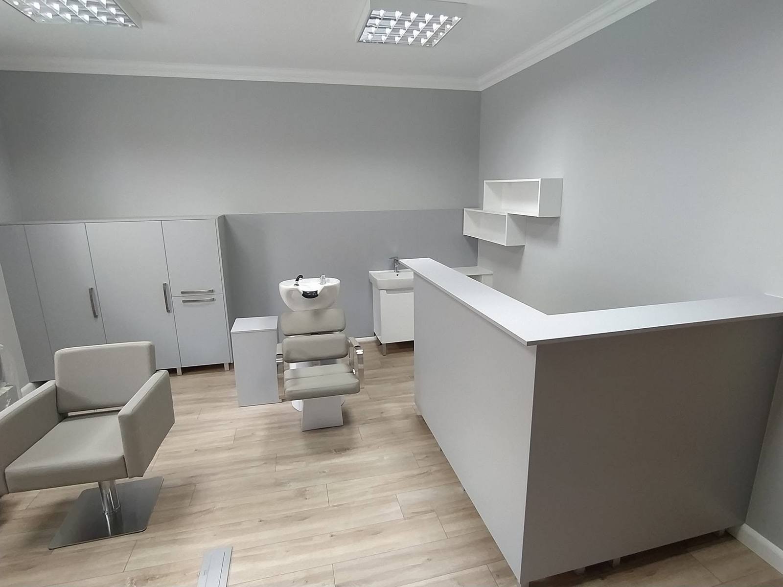 Friseursalon mit grauem Tresen und Schränken für Produkte