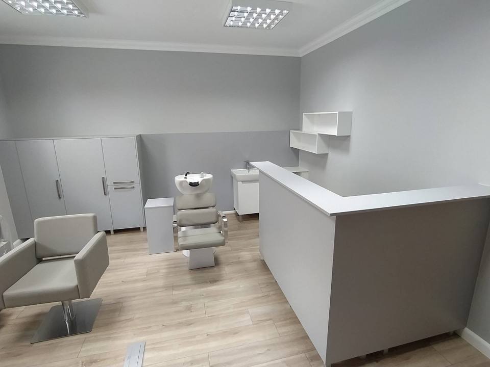 Friseursalon mit grauem Tresen und Schränken für Produkte