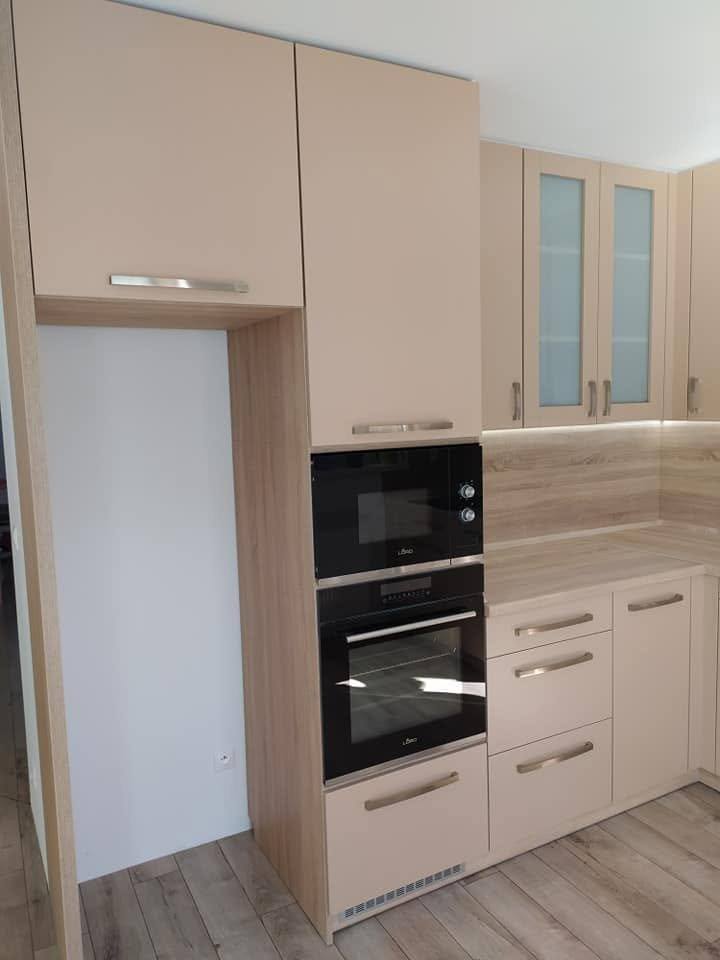Cappuccino-Hochschrank mit Backöfen neben verglasten Kästen.