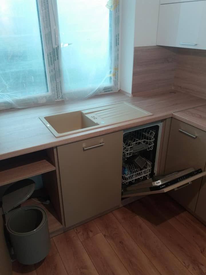 Cappuccino-Zeile unter dem Fenster mit offenem Geschirrspüler