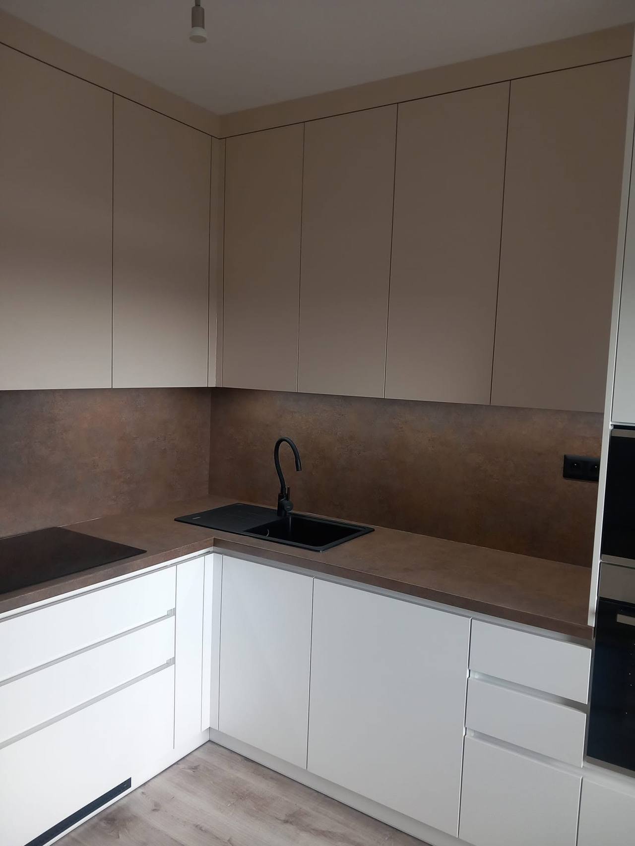 L-Küche mit Rückwand in Rostoptik und Oberkästen in Kaschmir