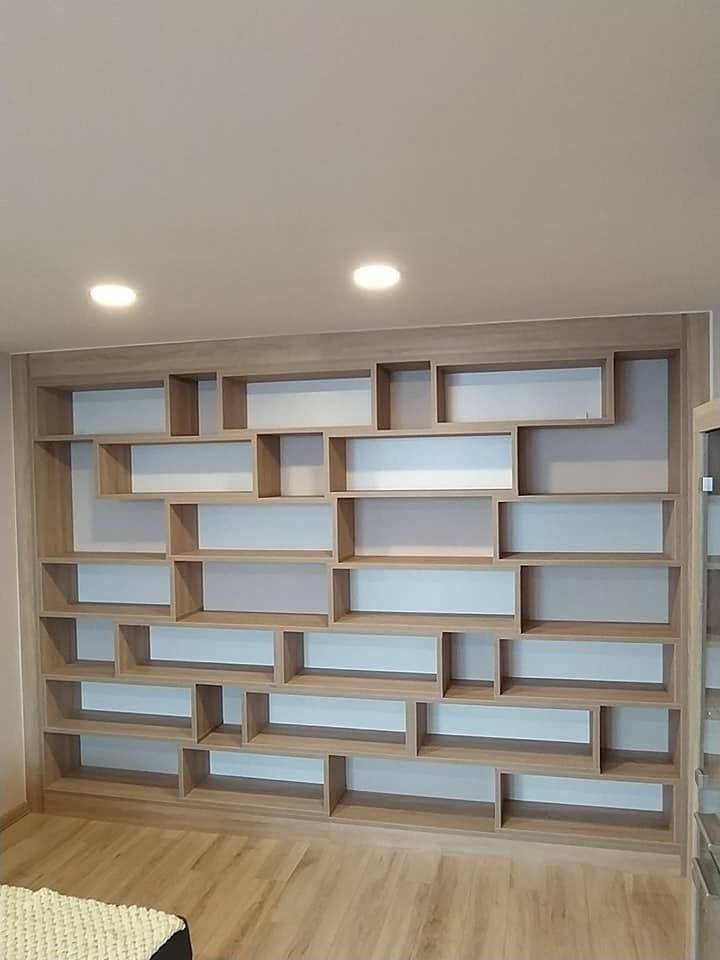 Bücherwand über die ganze Wand mit Eichenfächern und hellem Hintergrund